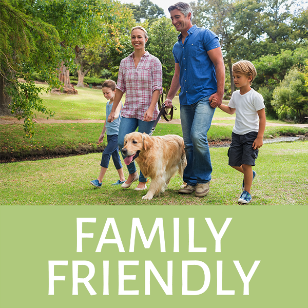 Family walking with dog in park labeled Family Friendly