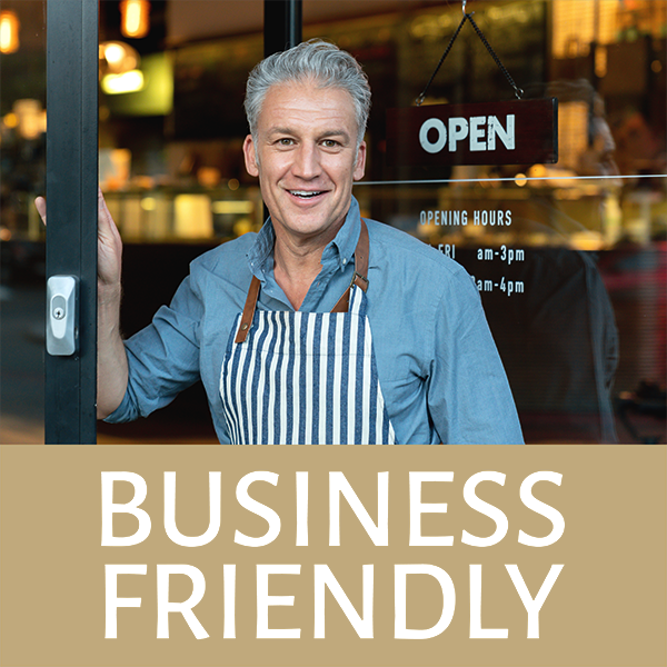 Shop keeper at store entrance labeled Business Friendly