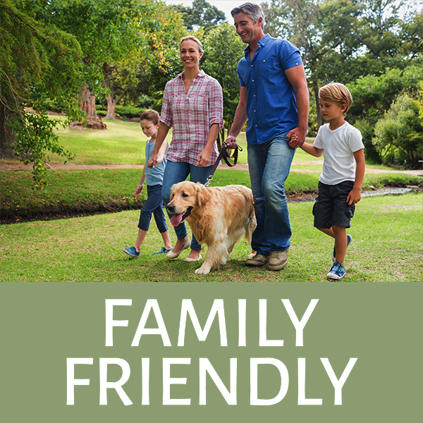 Family walking with dog in park labeled Family Friendly