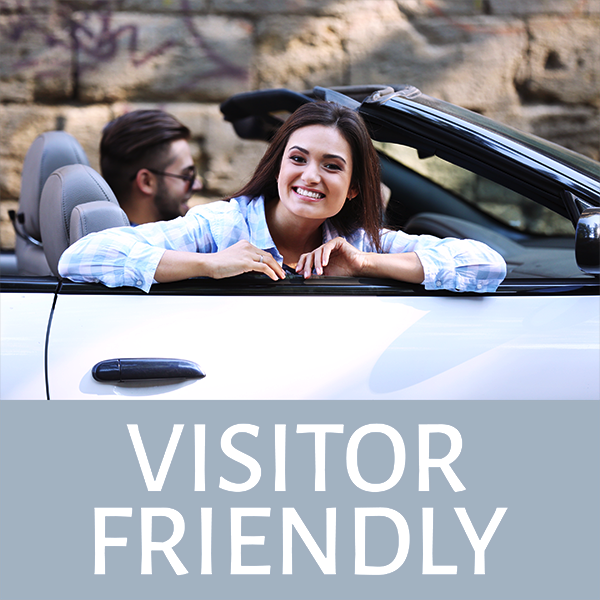 Young couple in convertible labeled Visitor Friendly